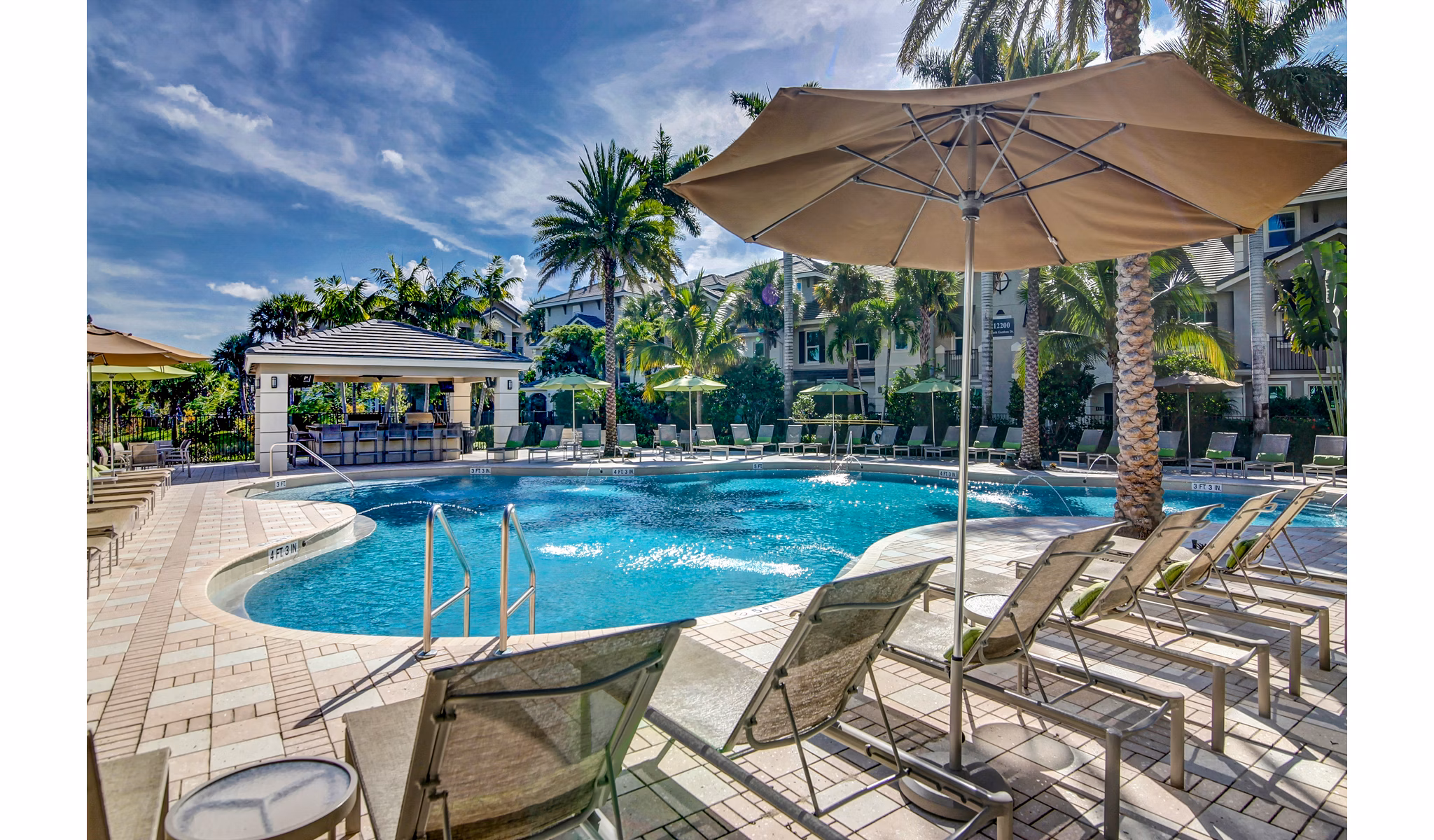Resort-style pool at The Quaye at Palm Beach Gardens Apartments, offering relaxation and leisure in a luxury setting