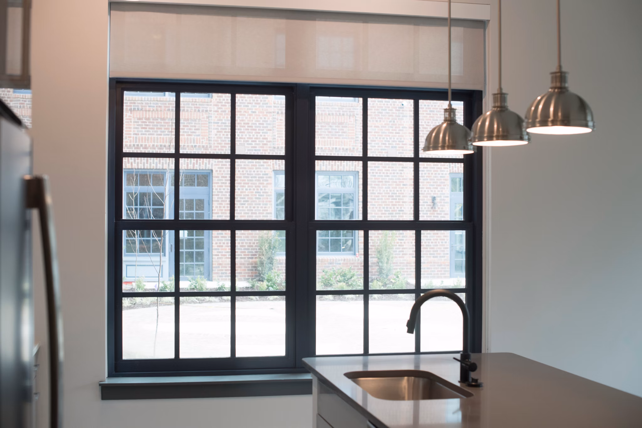 Modern kitchen featuring stainless steel appliances and quartz countertops in The Guild Apartments