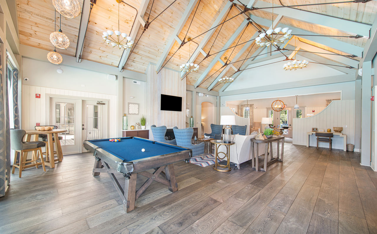 Game room with pool table and lounge seating at Atlantic at Grand Oaks Apartments