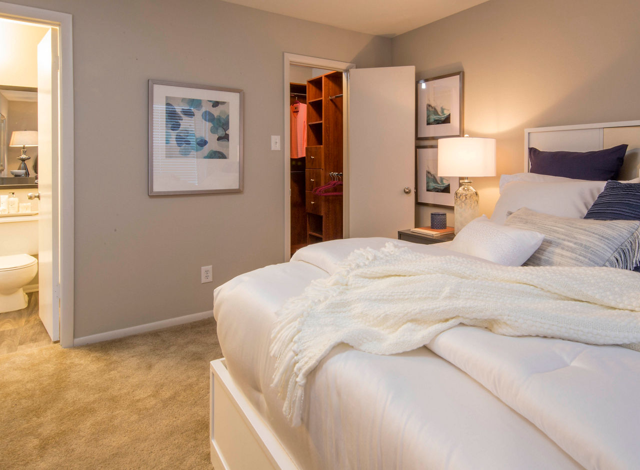 Bedroom with plush carpeting and scenic window views at Lakeside Mill Apartments