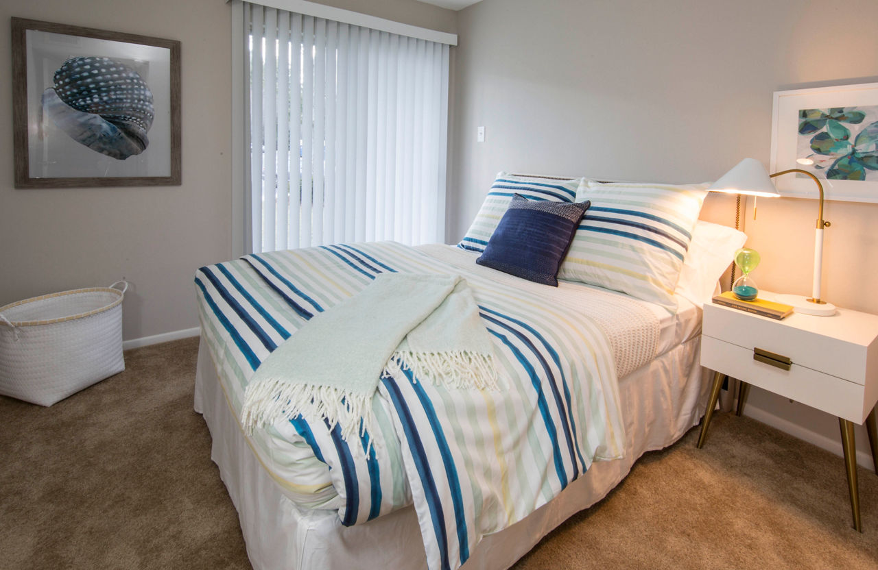 Spacious bedroom with large bay windows at Lakeside Mill Apartments, a luxury property by Greystar