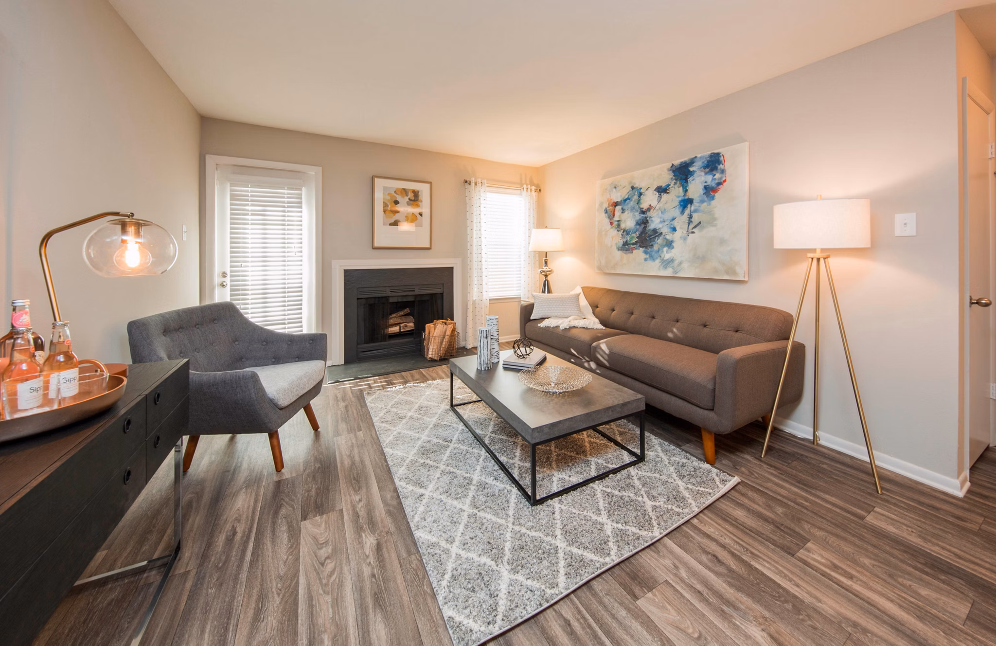 Spacious living room with modern decor in Lakeside Mill Apartments, featuring comfy seating and large windows