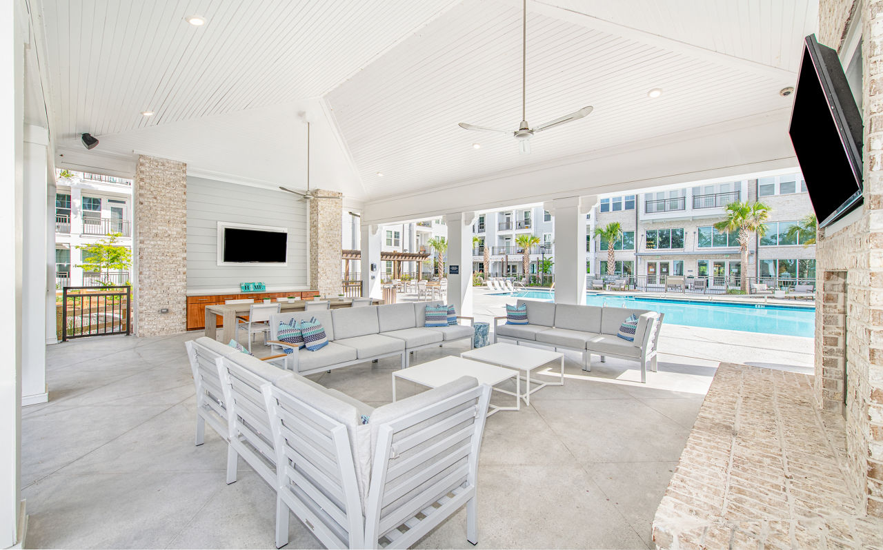 Charming patio with seating and lush greenery at Overture Daniel Island Apartments, offering a tranquil outdoor space for relaxation