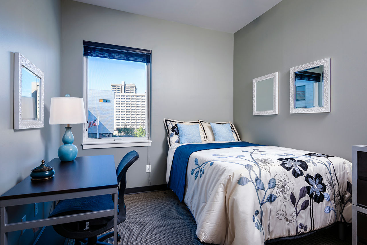 Spacious bedroom with modern decor and ample natural light at Campus West Apartments