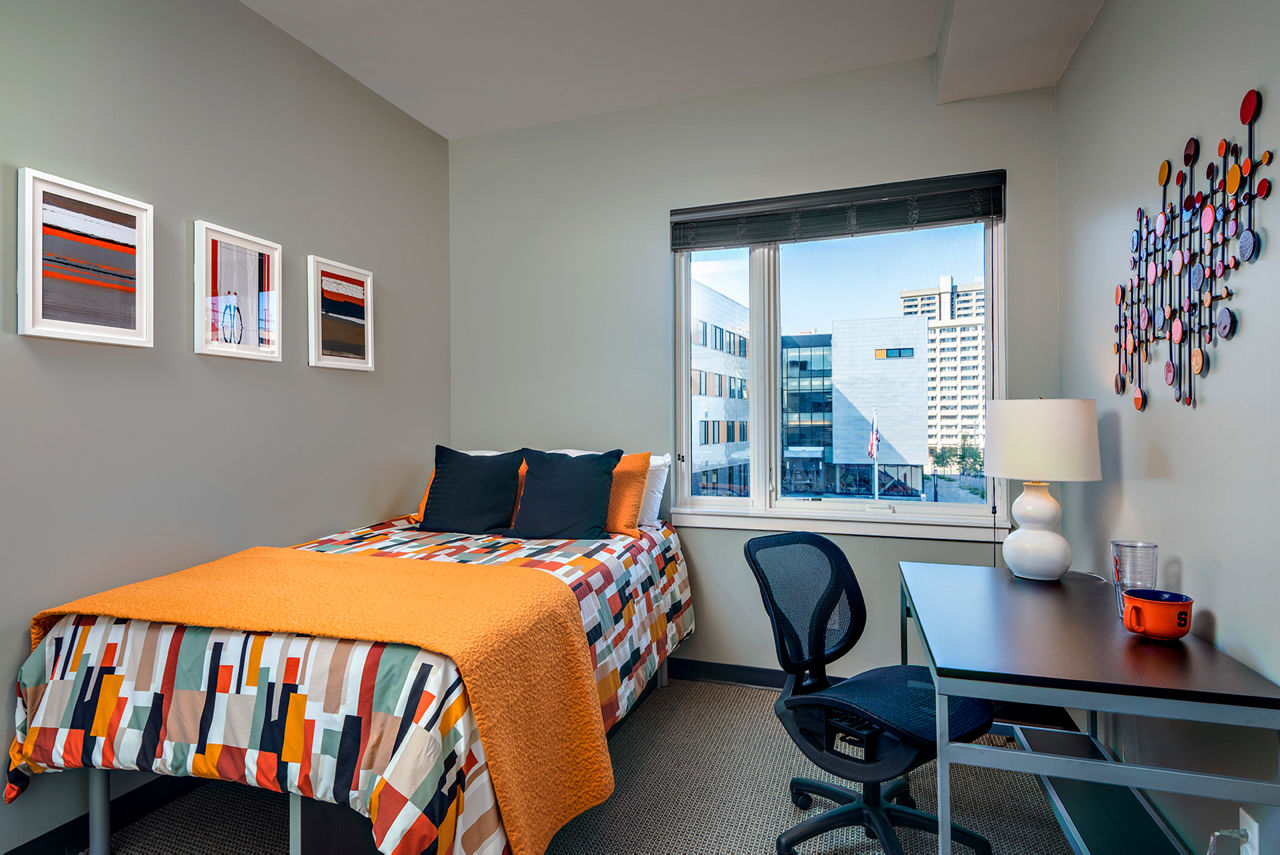 Cozy bedroom with modern decor at Campus West Apartments, offering luxury student living near university campus