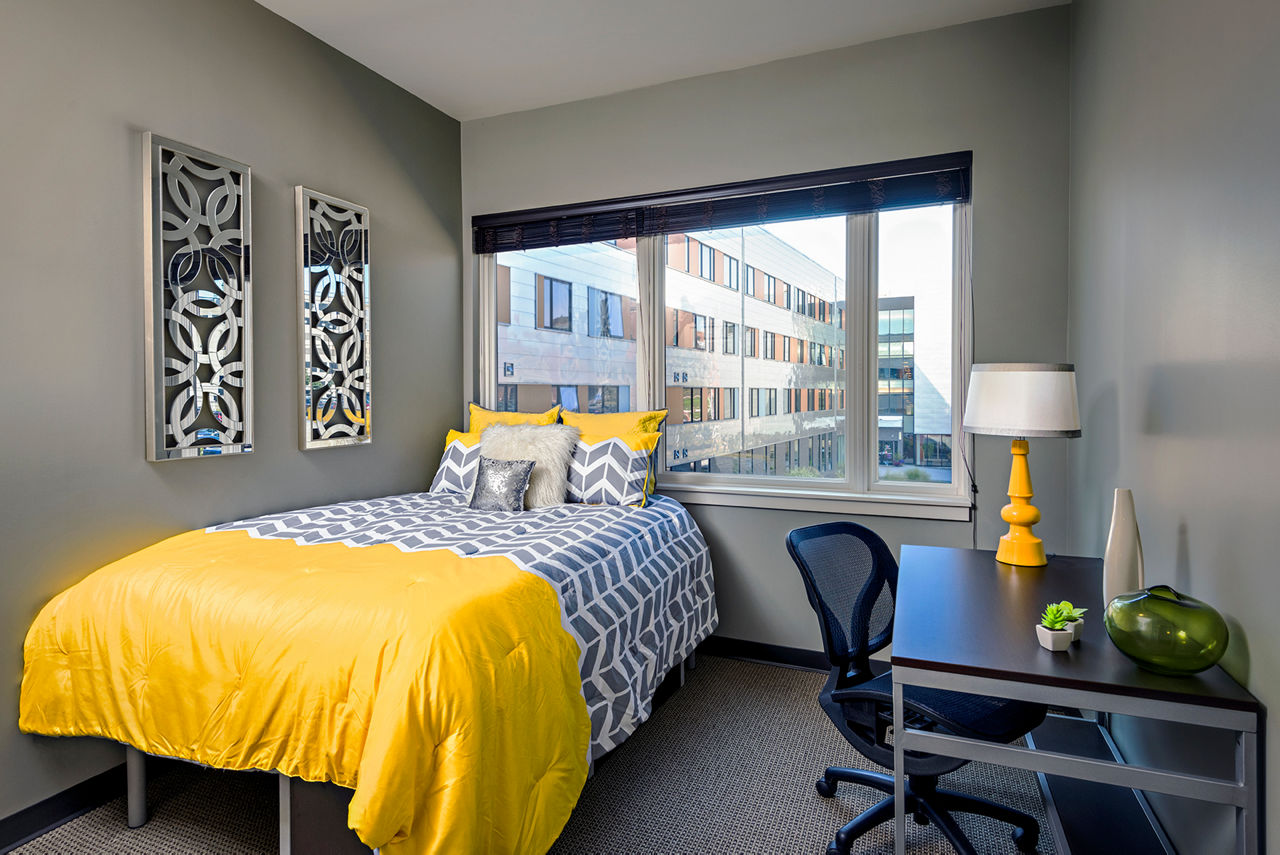 Cozy bedroom with natural light at Campus West Apartments, luxury living spaces for students