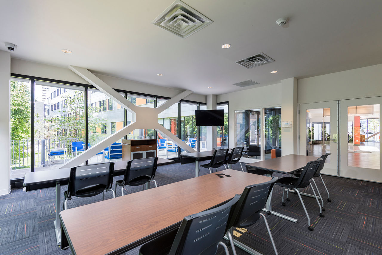 Meeting room with modern conference table and chairs at Campus West Apartments, ideal for gatherings and collaborative work