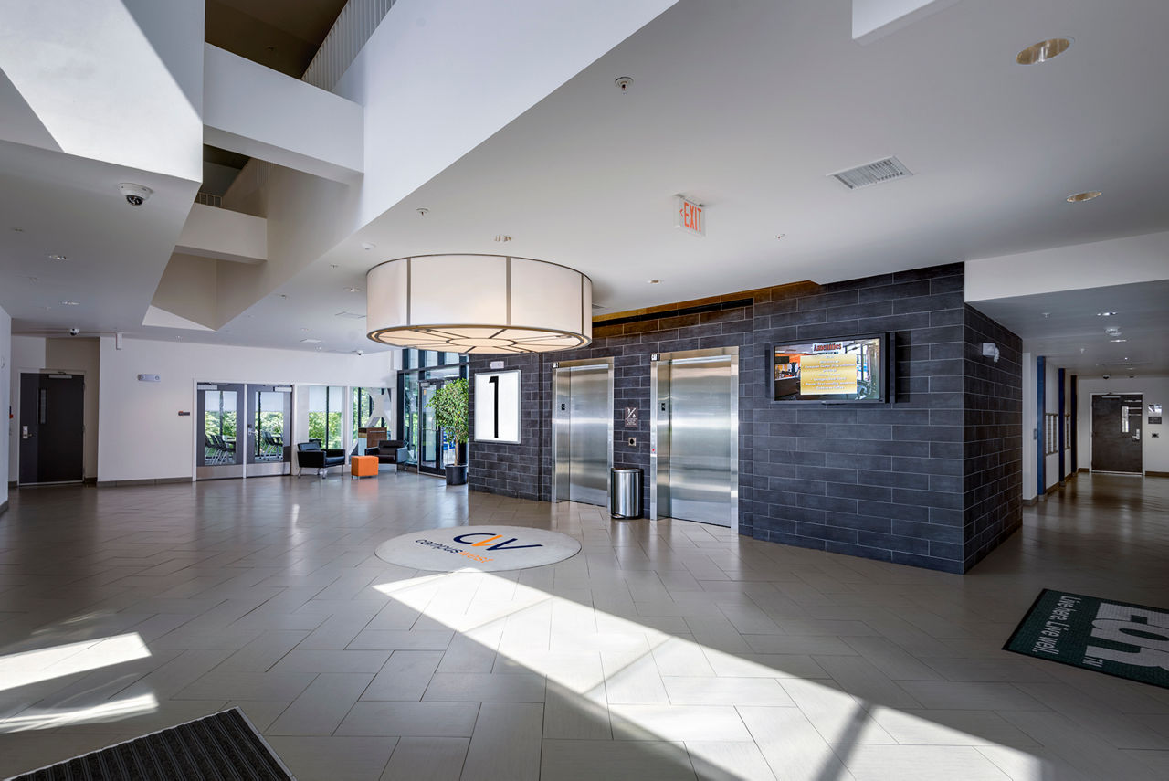 Campus West Apartments: Modern front lobby with elevators in luxury apartments, showcasing elegant design and sophisticated ambiance