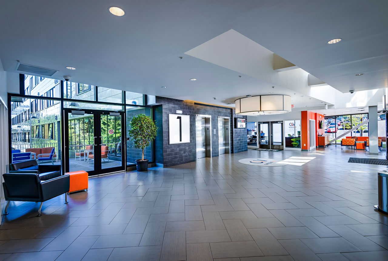 Campus West Apartments: Modern clubhouse front lobby featuring comfortable seating and contemporary design elements