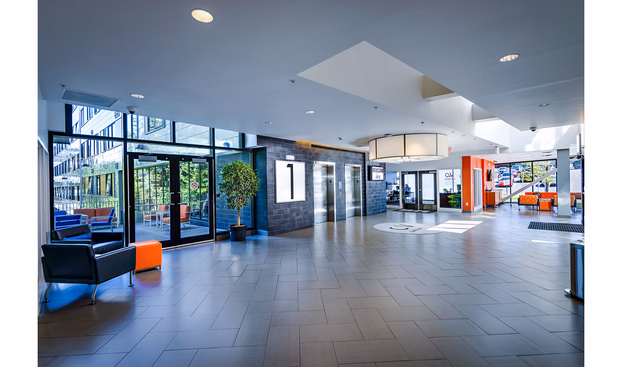 Campus West Apartments: Modern clubhouse front lobby featuring comfortable seating and contemporary design elements