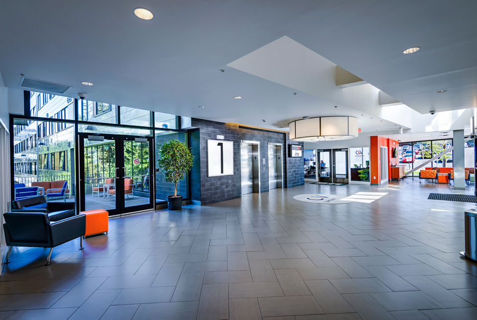 Campus West Apartments: Modern clubhouse front lobby featuring comfortable seating and contemporary design elements