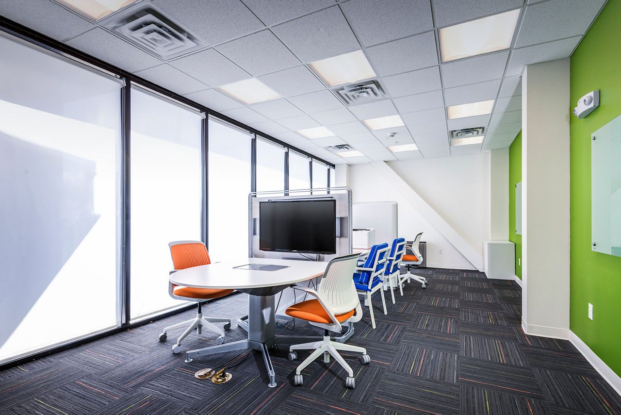 Modern business center with workstations and meeting areas at Campus West Apartments