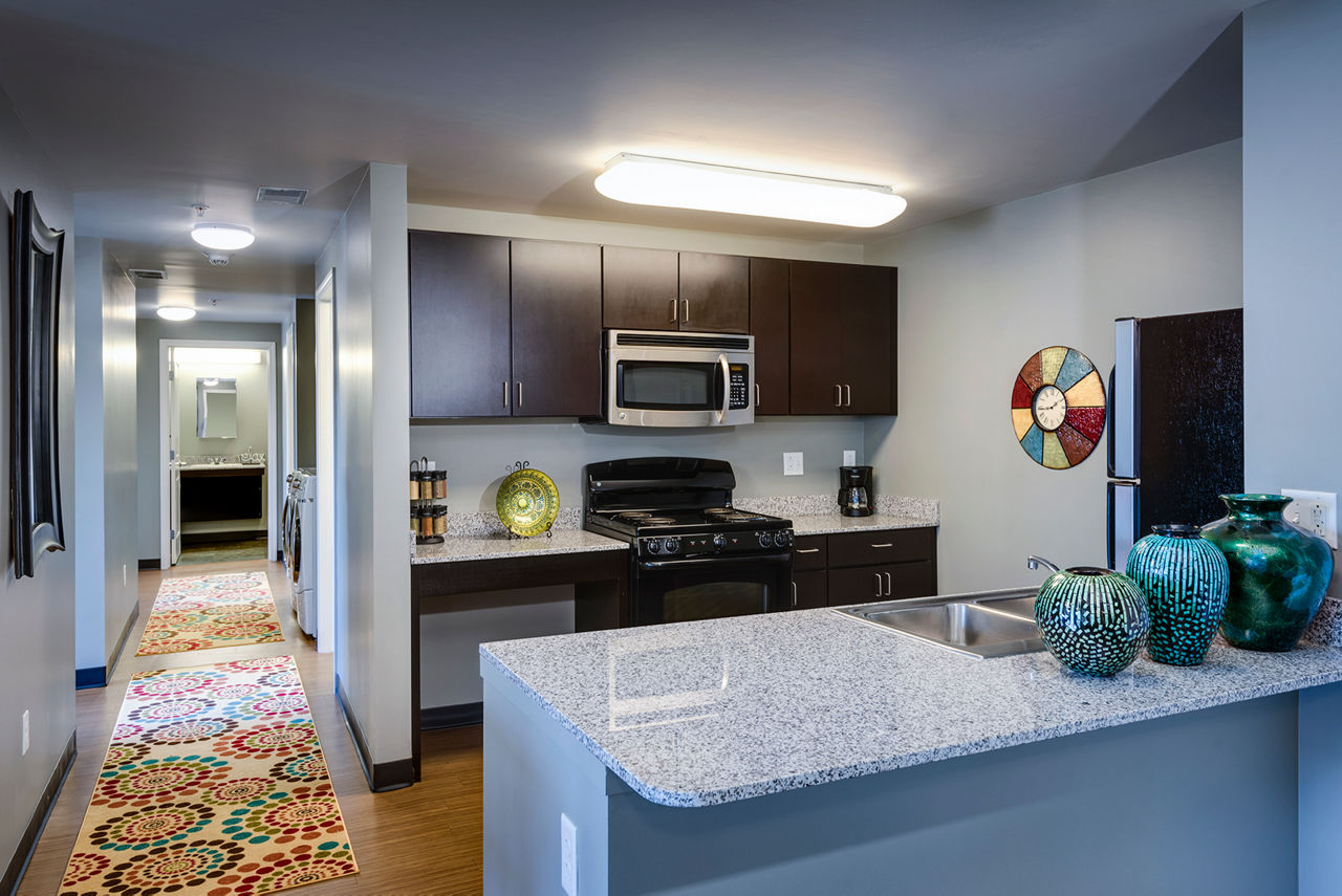 Modern kitchen with stainless steel appliances in Campus West Apartments