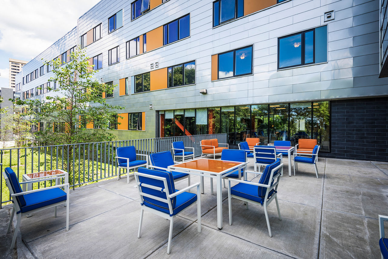 Private patio with seating at Campus West Apartments, ideal for relaxation and enjoying the outdoors in a vibrant community setting