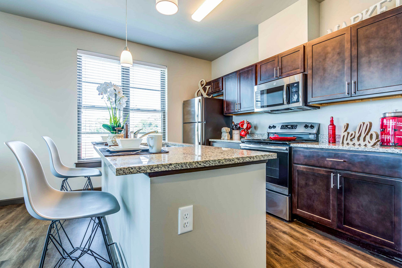Modern kitchen featuring stainless steel appliances in Maplewood Apartments