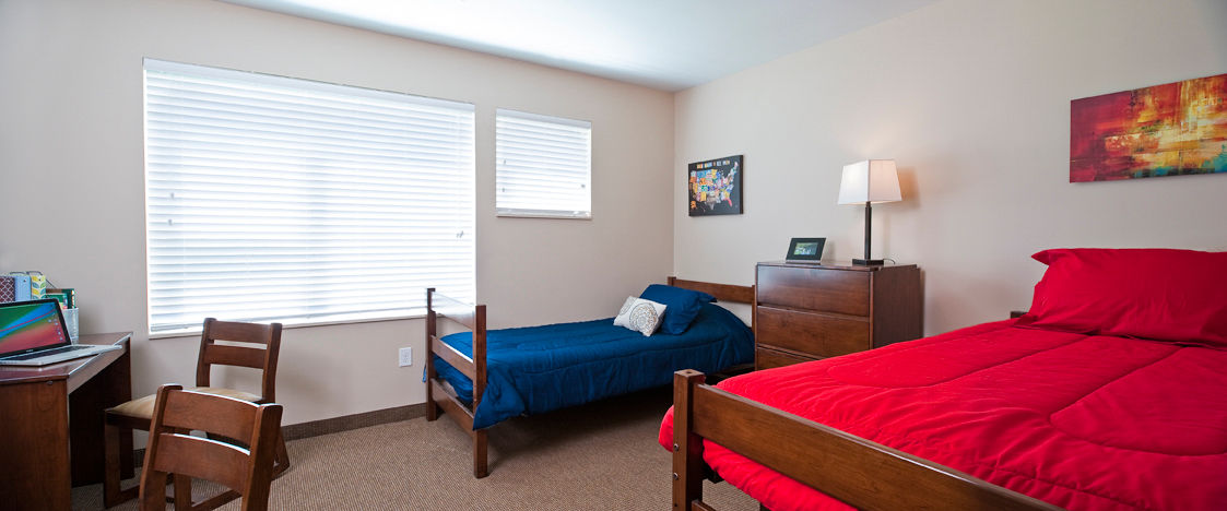 Bedroom with modern decor and large windows in Centennial Hall Apartments