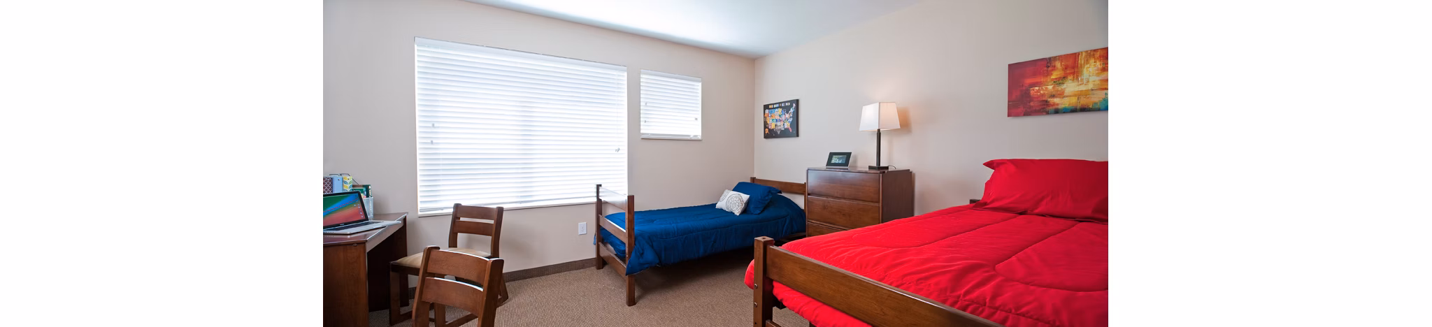 Bedroom with modern decor and large windows in Centennial Hall Apartments