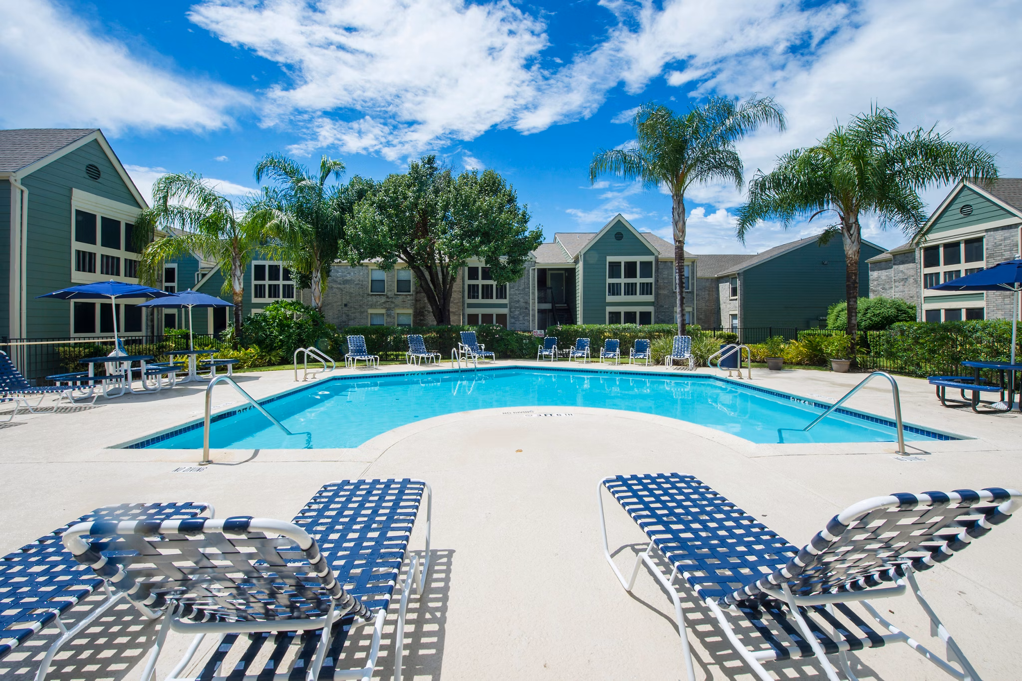 Relaxing poolside retreat at Willow Springs Apartments featuring sparkling water and lush landscaping