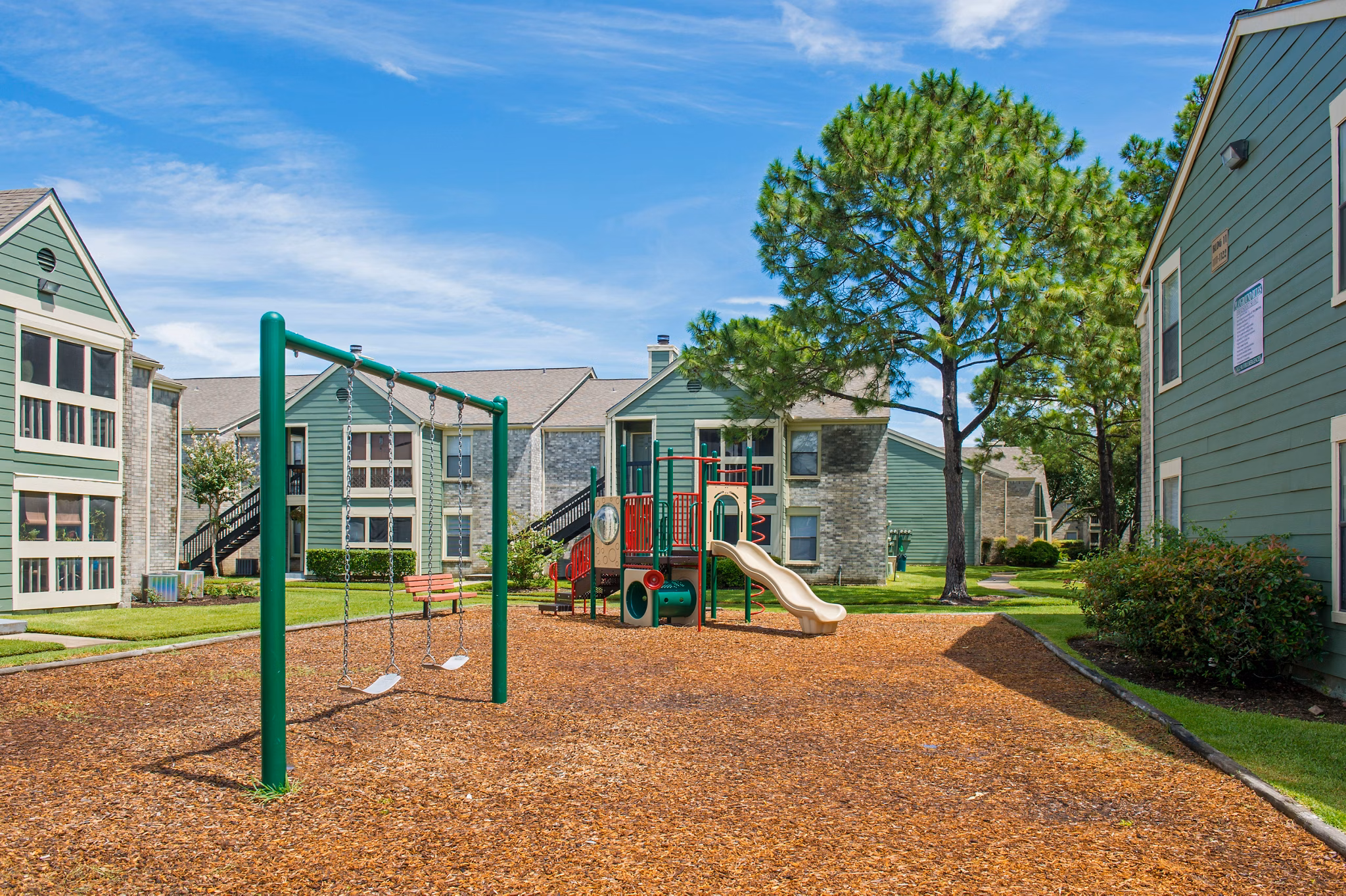 Playground with modern equipment at Willow Springs Apartments, offering a fun and safe play area for children