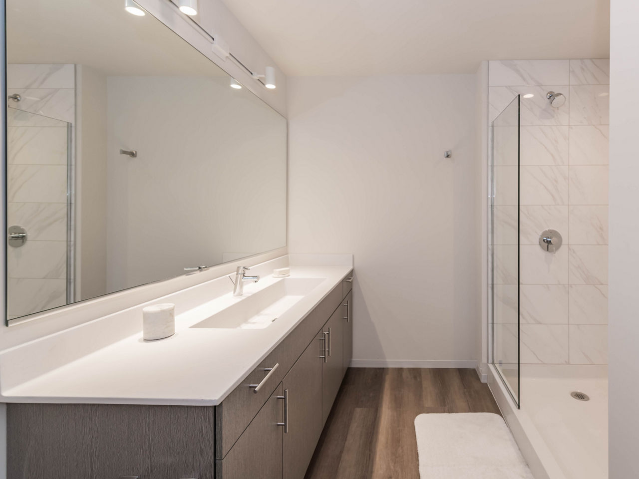 Modern bathroom with sleek fixtures and ample lighting at Coeval Apartments