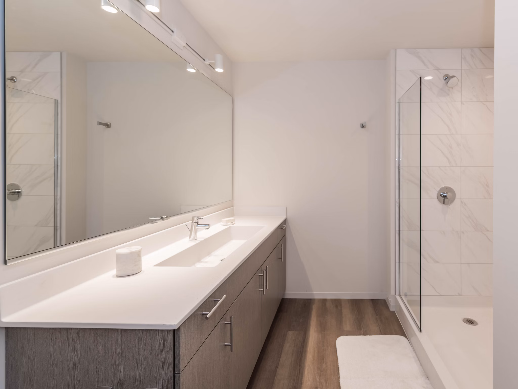 Modern bathroom with sleek fixtures and ample lighting at Coeval Apartments