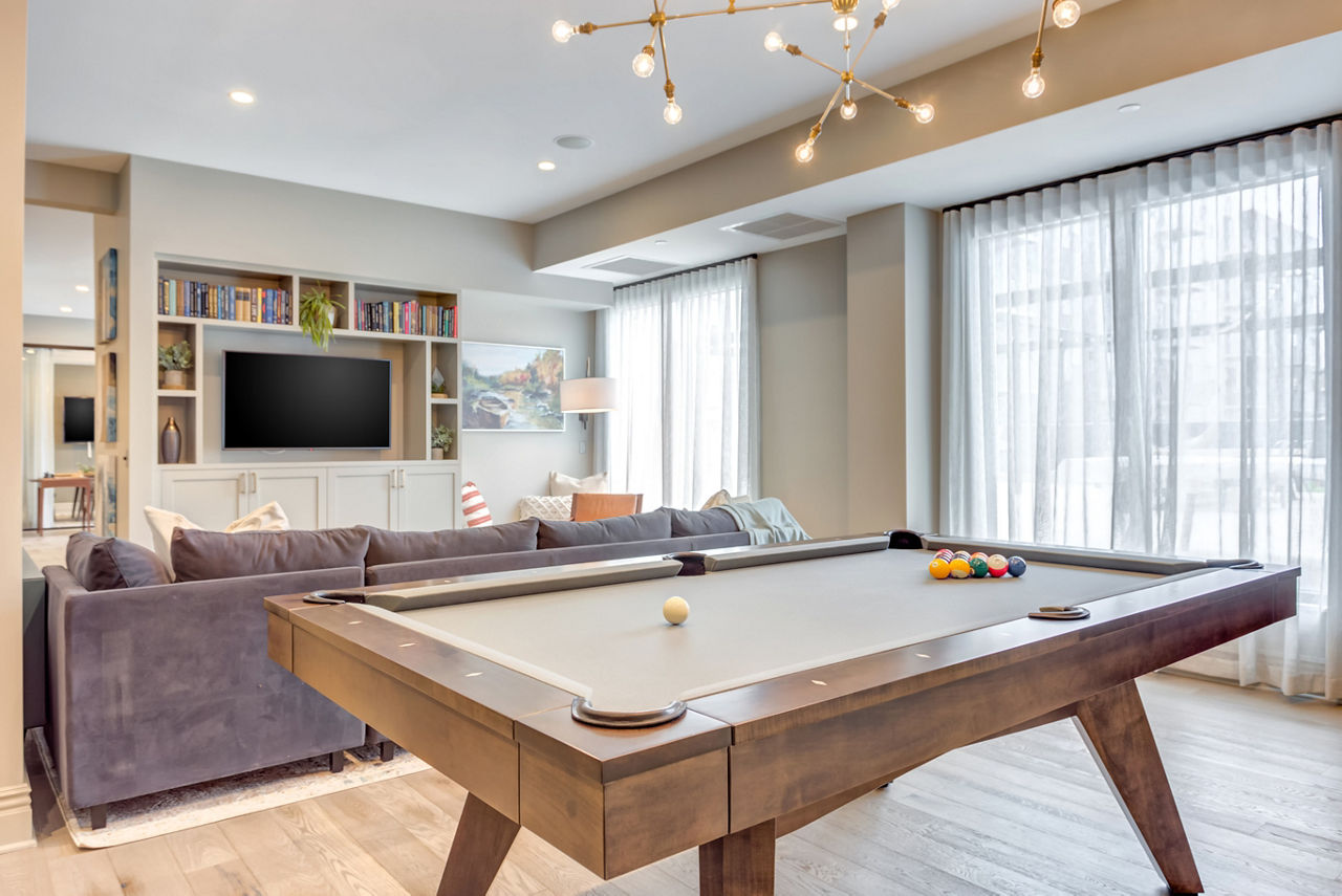 Game room with pool table and lounge seating at The Marke of Elmhurst Apartments