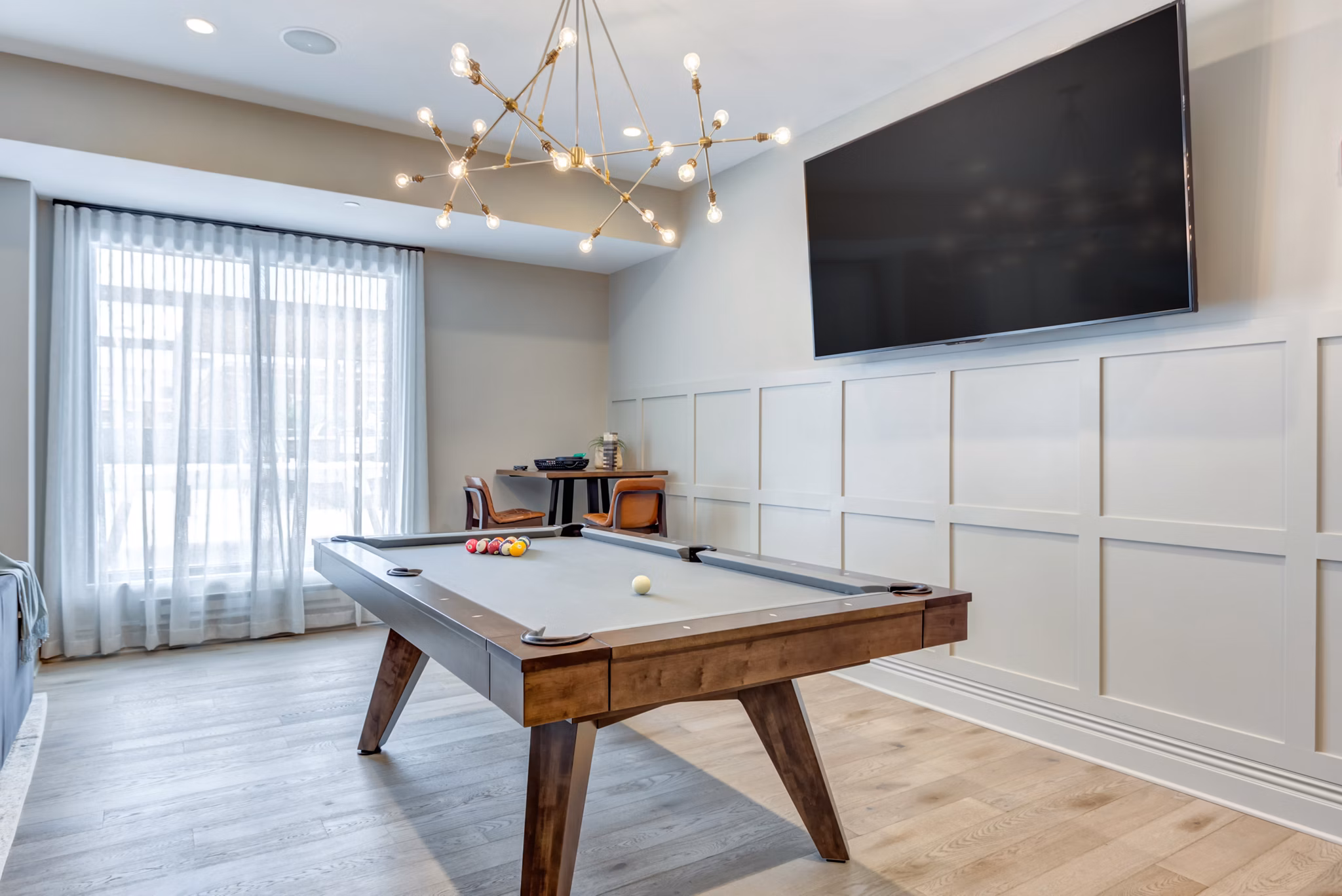 Game room with pool table and lounge seating at The Marke of Elmhurst Apartments, offering luxury living and recreational amenities