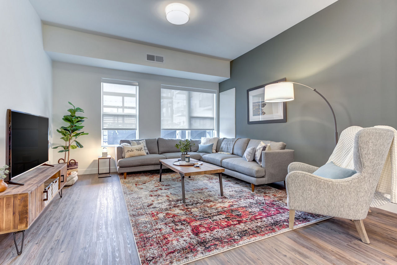 Elegant living room with stylish furniture and large windows at The Marke of Elmhurst Apartments