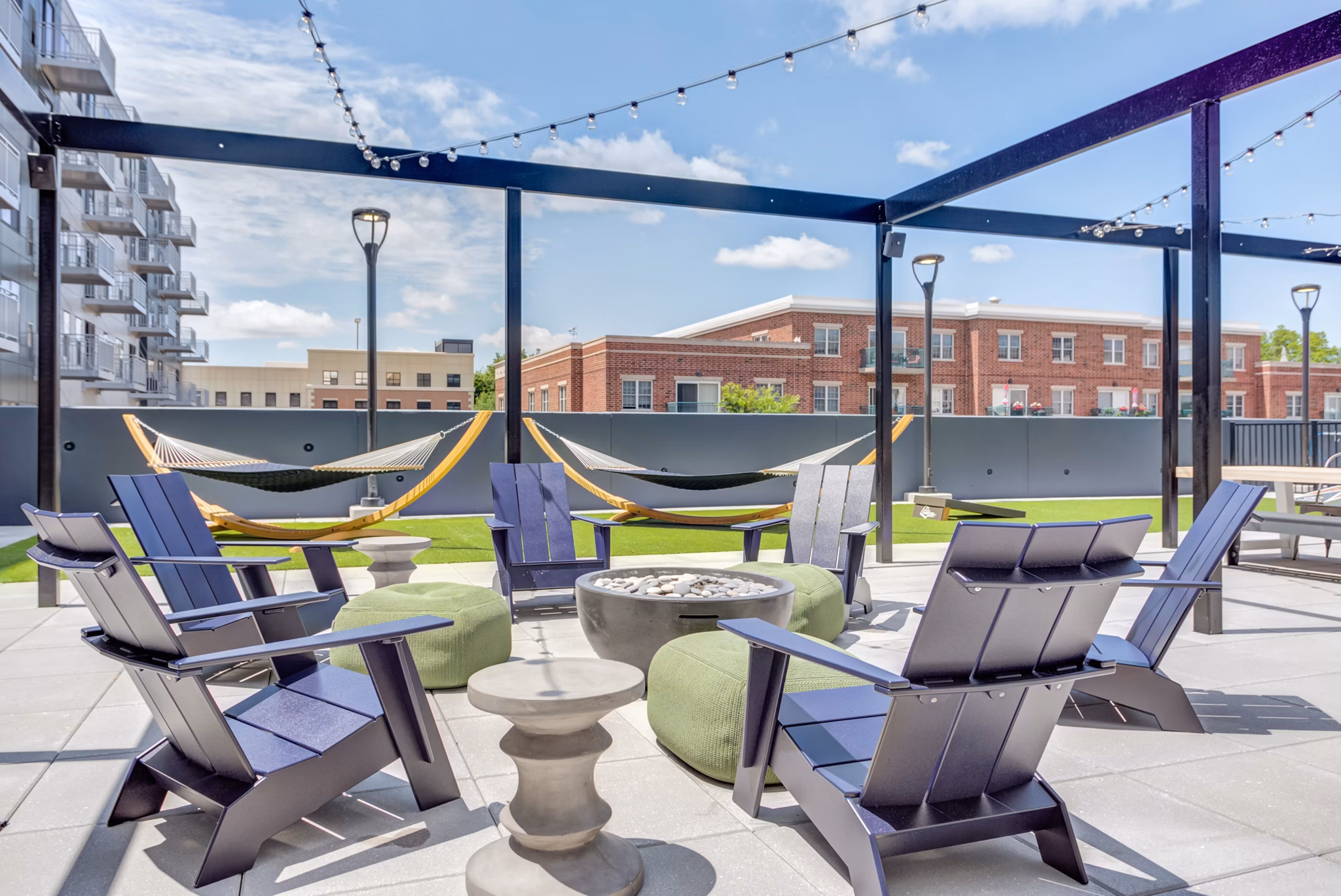Cozy fire pit lounge area at The Marke of Elmhurst Apartments for social gatherings and relaxation