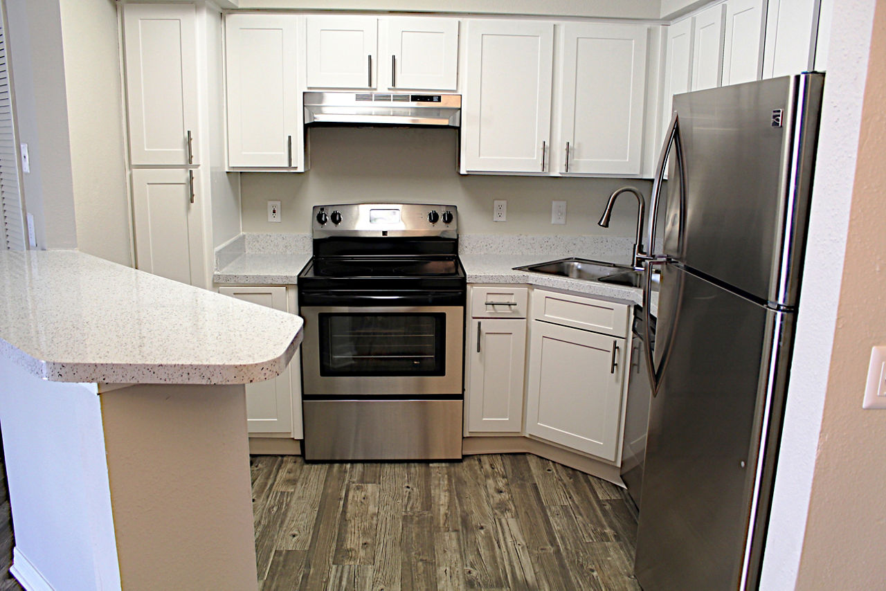 Modern kitchen with stainless steel appliances in Island Club Apartments