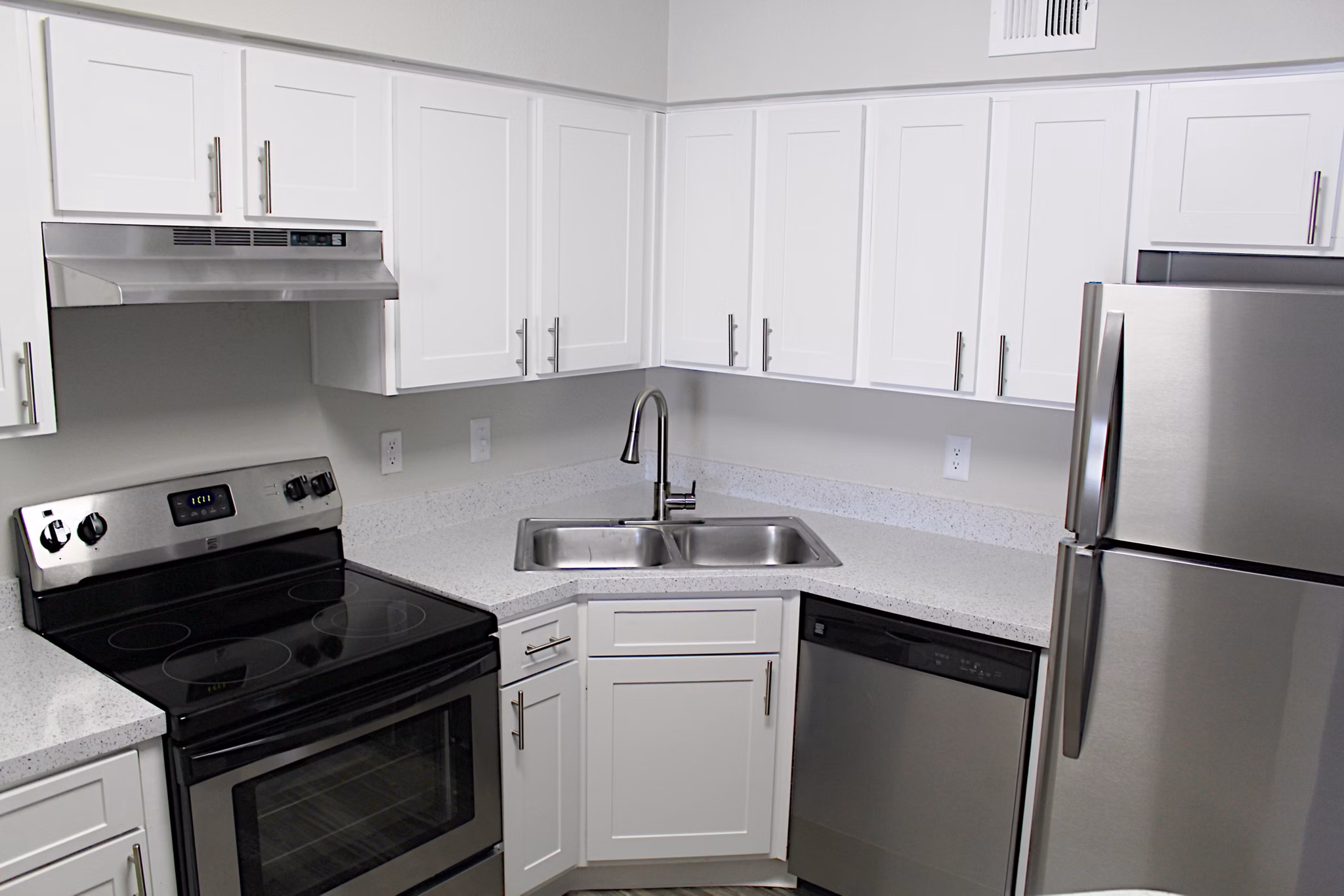 Modern kitchen with granite countertops and stainless steel appliances in Island Club Apartments