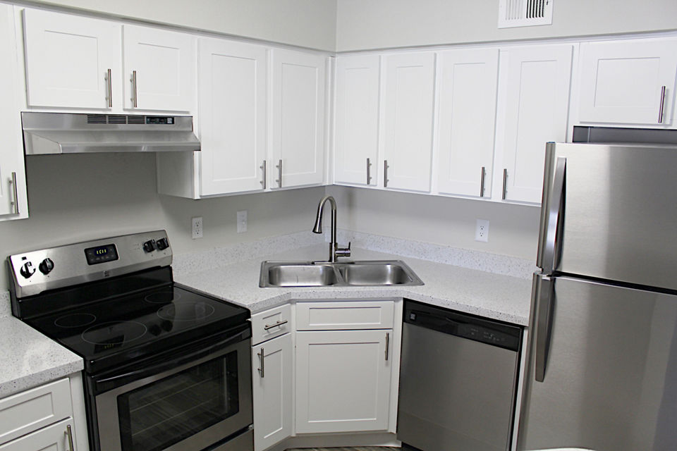 Modern kitchen with granite countertops and stainless steel appliances in Island Club Apartments