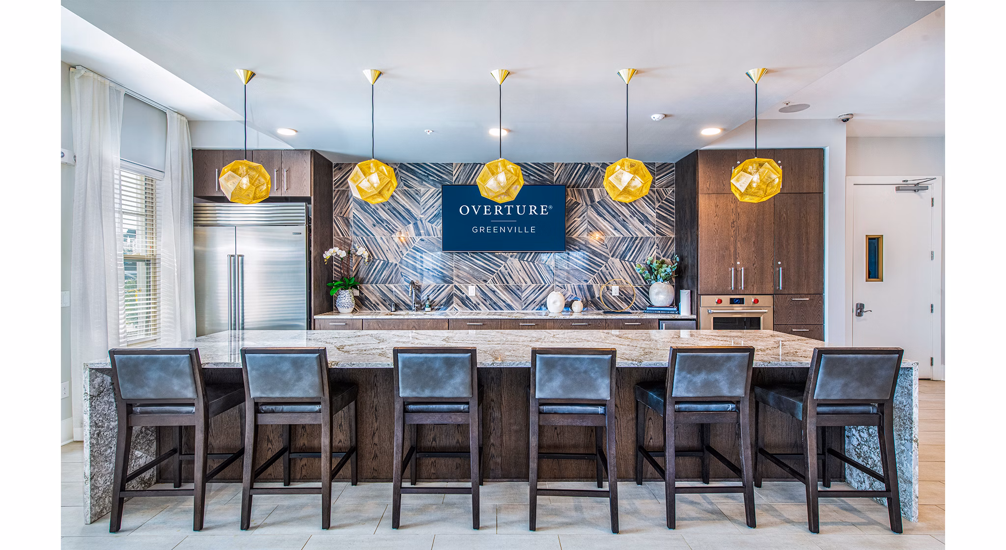 Clubhouse kitchen featuring modern appliances and sleek countertops at Overture Greenville Apartments, a luxury living community