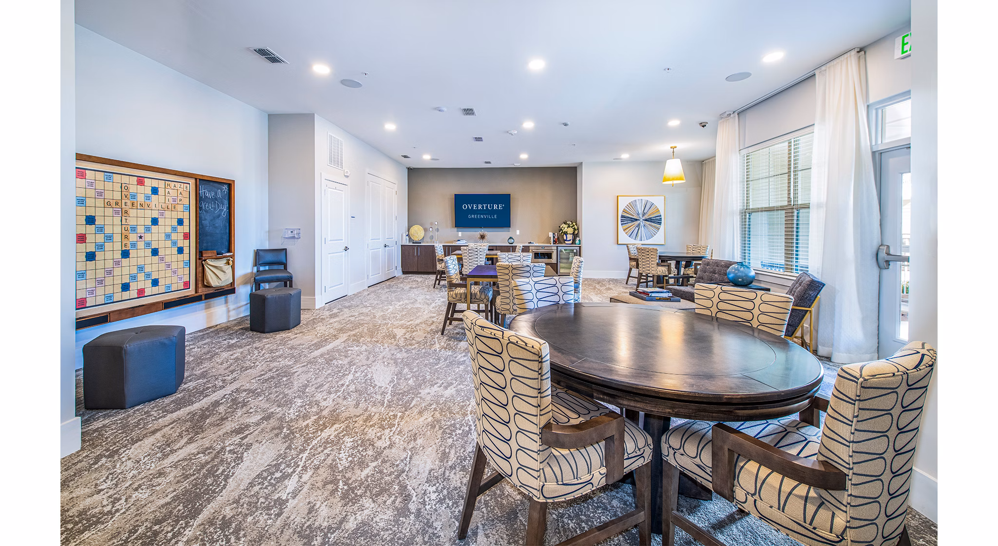 Vibrant clubhouse game room with billiards and lounge seating at Overture Greenville Apartments