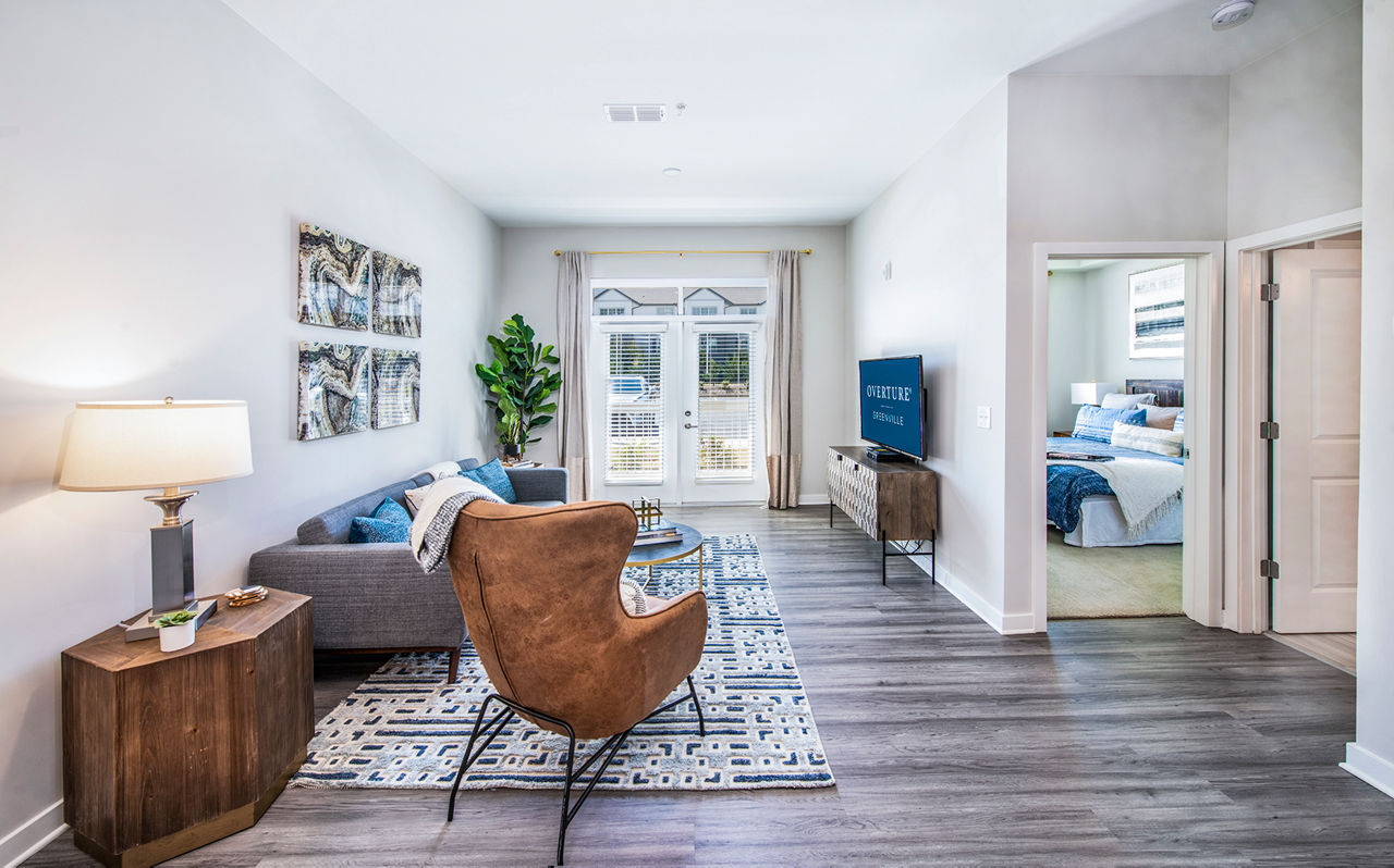 Spacious living room with modern decor and natural light in Overture Greenville Apartments