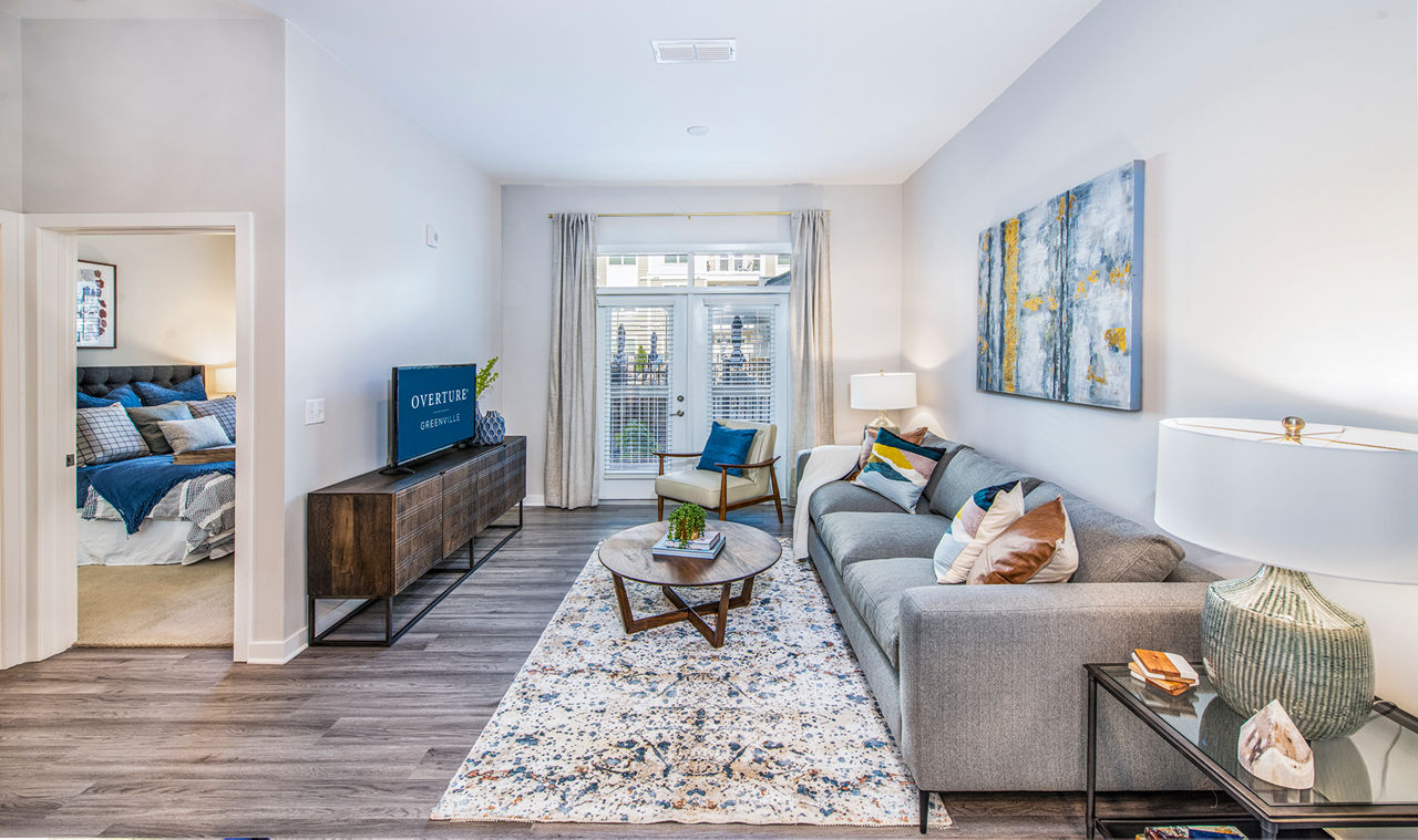Modern open-concept living room with natural light at Overture Greenville Apartments