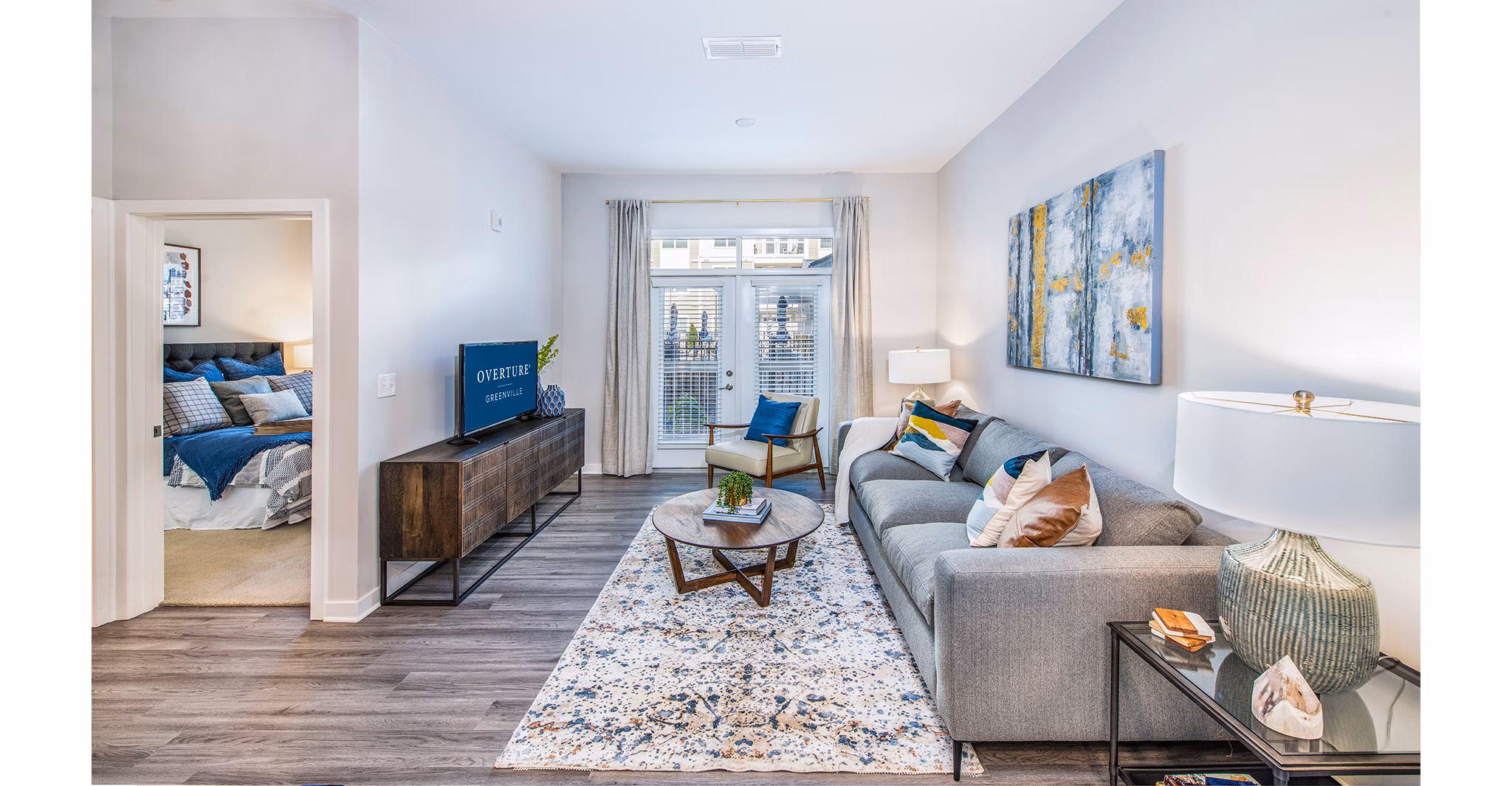 Modern open-concept living room with natural light at Overture Greenville Apartments