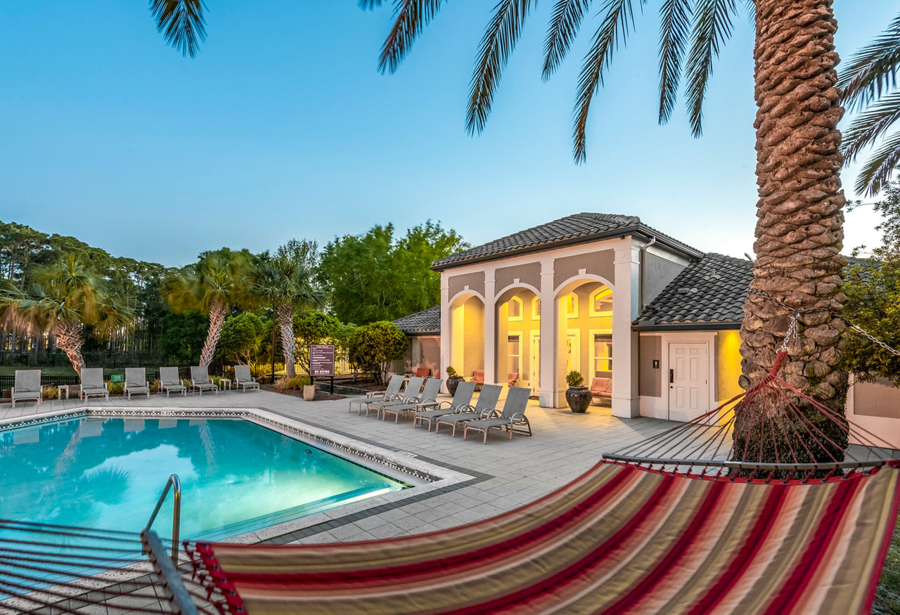 Resort-style pool with lush landscaping at Legacy On The Bay Apartments, offering luxurious leisure in a vibrant community setting