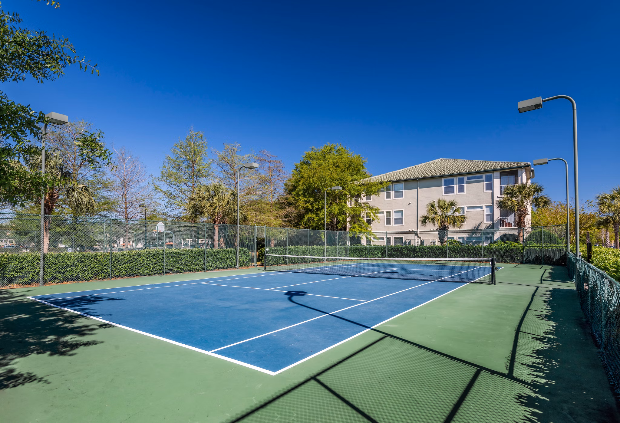 Sport court for basketball and tennis at Legacy On The Bay Apartments, featuring well-maintained surfaces for recreational activities