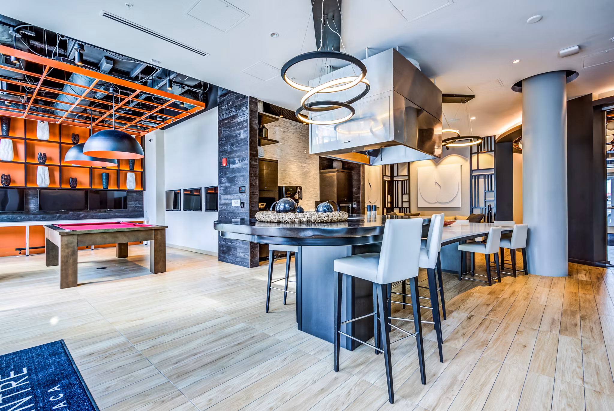 Clubhouse game room with billiards table and modern seating at City Centre Ithaca Apartments