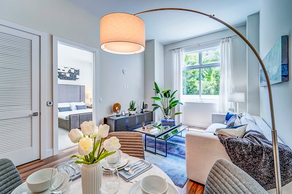 Dining area with sleek furniture and modern lighting at Oversea at Flagler Banyan Square Apartments Elegant space for luxury living experiences