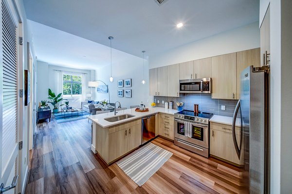 Modern kitchen with stainless steel appliances at Oversea at Flagler Banyan Square apartments