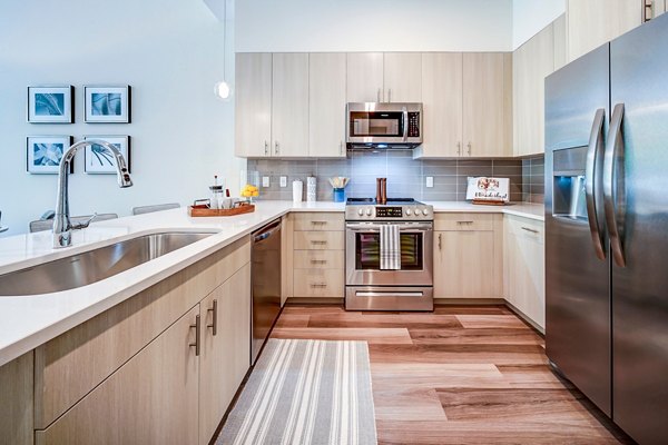 Modern kitchen with stainless steel appliances at Oversea at Flagler Banyan Square Apartments
