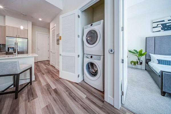 Laundry room featuring modern washers and dryers at Oversea at Flagler Banyan Square Apartments