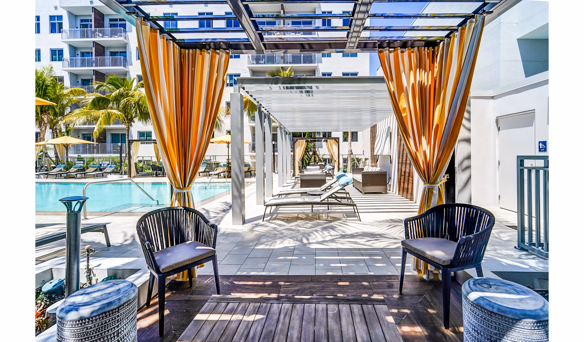 Modern pool area with palm trees at Oversea at Flagler Banyan Square Apartments