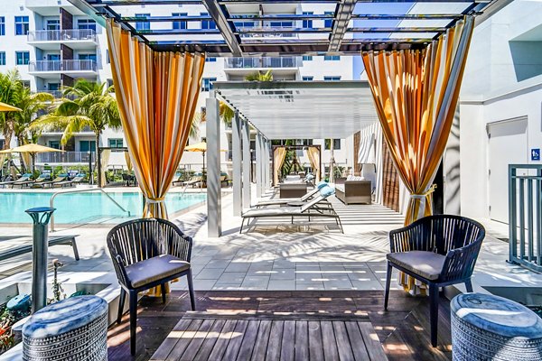 Modern pool area with palm trees at Oversea at Flagler Banyan Square Apartments