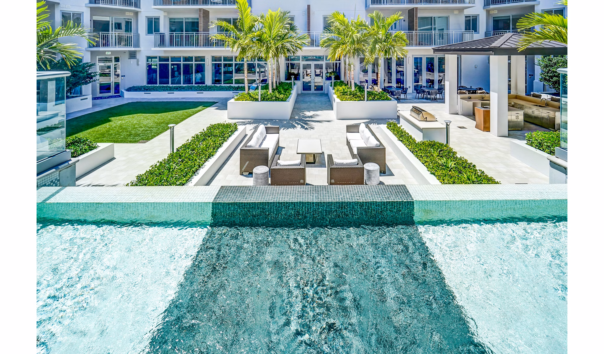 Courtyard with lush greenery at Oversea at Flagler Banyan Square Apartments