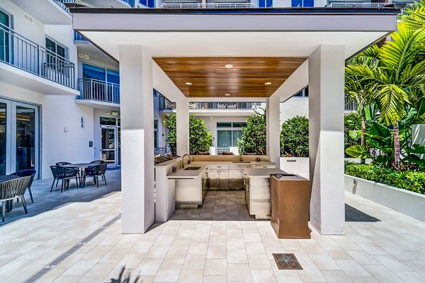 Serene courtyard at Oversea at Flagler Banyan Square Apartments featuring lush landscaping and seating areas