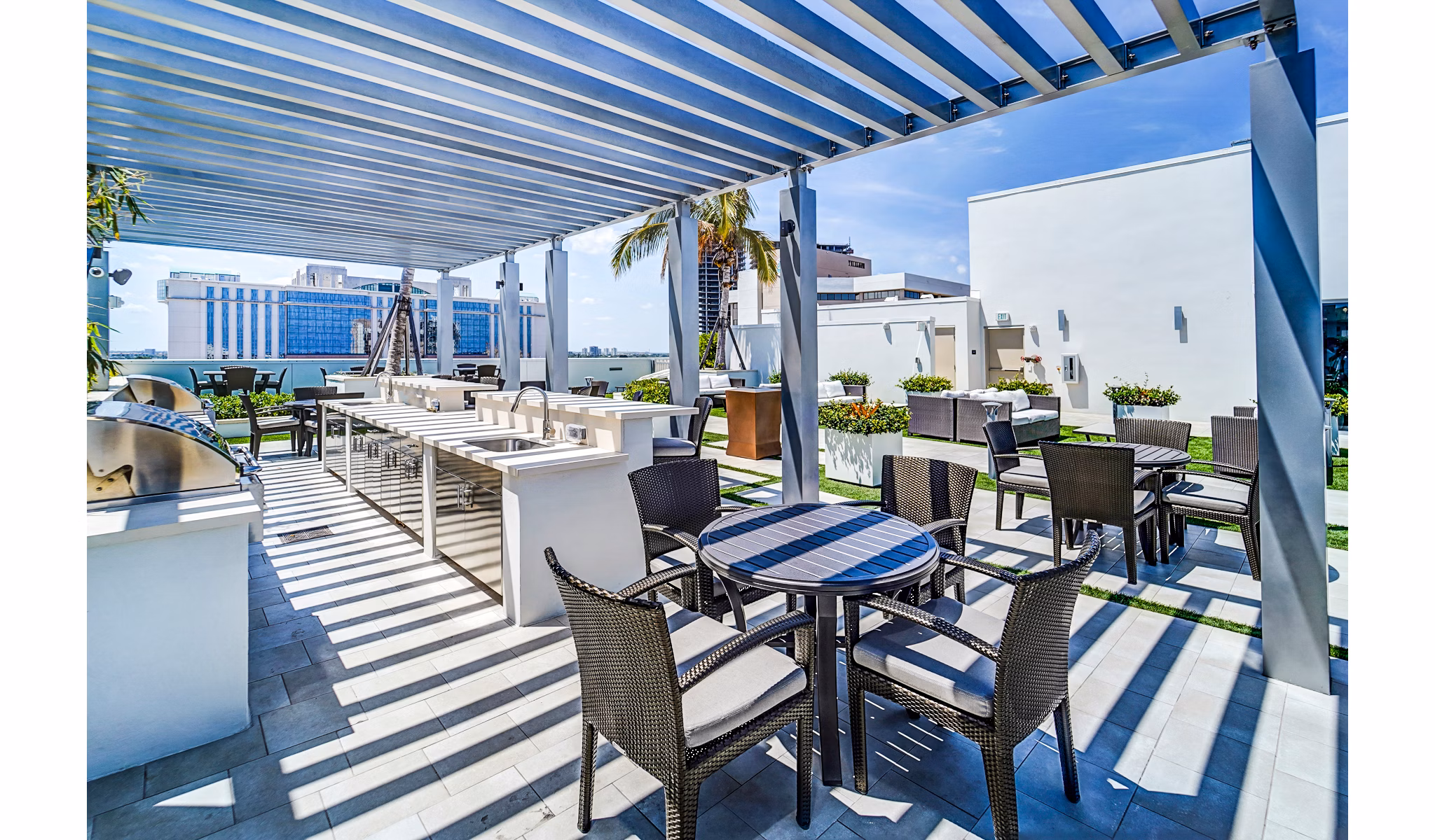Outdoor grill area with modern seating at Oversea at Flagler Banyan Square Apartments