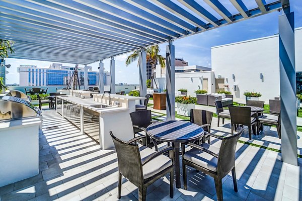 Outdoor grill area with modern seating at Oversea at Flagler Banyan Square Apartments
